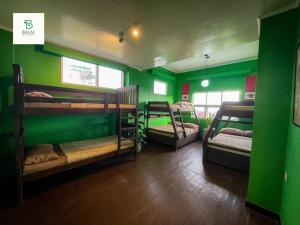 a room with three bunk beds with green walls at Balai Berde Baguio in Baguio