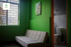 a green room with a couch in a room with a window at Balai Berde Baguio in Baguio +51 photos