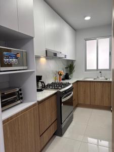 une cuisine avec une cuisinière et un micro-ondes dans l'établissement Casa Luna a 5 min aeropuerto 3Hb, à Santa Cruz Xoxocotlán