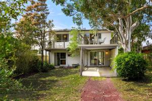 una vista exterior de una casa blanca con árboles en Sandpiper at Jervis Bay - Rustic Retreat, en Callala Beach