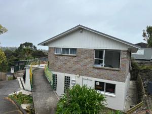 a house with a fence in front of it at Northcote holiday home- Next stop CBD in Auckland