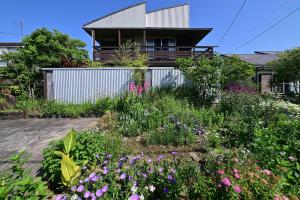 a garden in front of a house with flowers at SEBARI casa vacation rental in Kushima