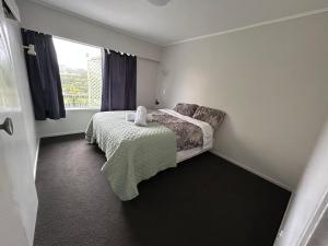 a small bedroom with a bed and a window at Northcote holiday home- Next stop CBD in Auckland +5 photos