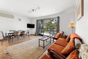 una sala de estar con un sofá y una mesa en Sandpiper at Jervis Bay - Rustic Retreat, en Callala Beach