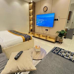 Una sala de estar con un televisor grande y un sofá. en ماي سويت, en Kuwait