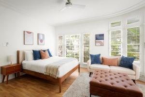 een witte slaapkamer met een bed en een bank bij Beverly Grove Hotel in Los Angeles