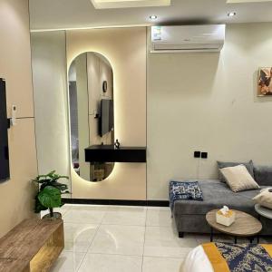 Una sala de estar con un sofá y un espejo. en ماي سويت, en Kuwait 5 fotos más