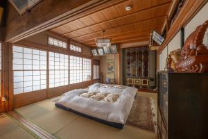 ein Schlafzimmer mit einem großen Bett in einem Zimmer mit Fenstern in der Unterkunft Kominka COCONE - Vacation STAY 18597 in Hashima + 27 Fotos