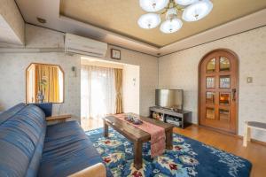 ein Wohnzimmer mit einem blauen Sofa und einem Tisch in der Unterkunft Kominka COCONE - Vacation STAY 18597 in Hashima