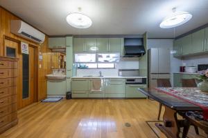 eine Küche mit grünen Schränken und Holzböden in der Unterkunft Kominka COCONE - Vacation STAY 18597 in Hashima