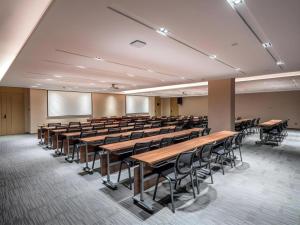 une salle de conférences vide avec des bureaux et des chaises dans l'établissement Lavande Hotel Chaozhou Fortune Center Lin Street, à Fengxi