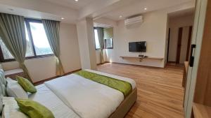 a hotel room with a bed and a tv at Sai Inn in Satara