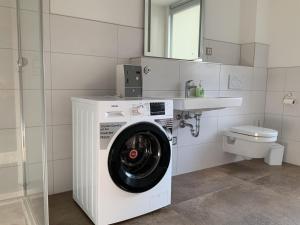 eine Waschmaschine in einem Badezimmer mit Toilette in der Unterkunft Appartement in Nordhausen mit Terrasse, Garten und Grill in Nordhausen