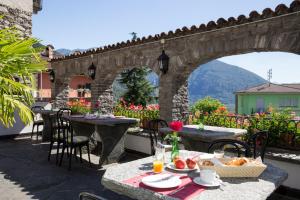 an outdoor patio with tables and a stone bridge at Hotel Antico in Intragna