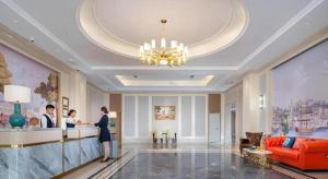 une femme debout au comptoir dans le hall de l'hôtel dans l'établissement Vienna Hotel Tianjin Chentangzhuang Metro Station, à Tianjin