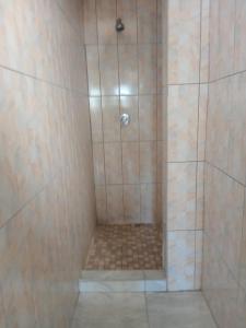 a shower with a glass door with a tiled shower at Maison Royale Lodge in Nongoma +17 photos