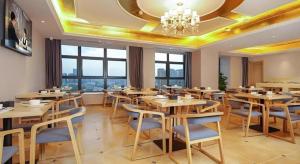 ein Restaurant mit Holztischen und -stühlen und Fenstern in der Unterkunft Vienna Hotel Chengdu University of Pertroleum Metro Station in Chengdu