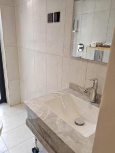 a bathroom with a sink and a mirror at كوخ ساره سبيشل in Al-ʿUla