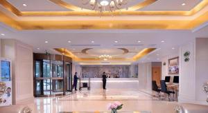 un homme se tient dans le hall d'un immeuble dans l'établissement Vienna Hotel Jinan Railway Station, à Jinan