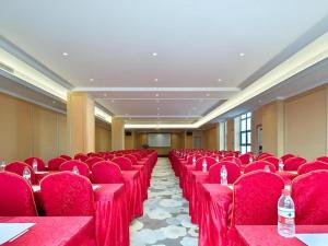 a row of red chairs in a conference room at Vienna Hotel Jiangxi Fengcheng Fnegkuang in Fengcheng