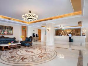 ein großes Wohnzimmer mit einem Sofa und einem Kronleuchter in der Unterkunft Vienna Hotel Shanxi Datong High-Speed Railway Station Wanda Plaza in Shuiposhi