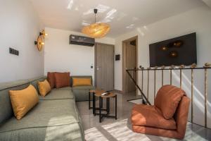 una sala de estar con un sofá y una silla en Rodos Nest with terrace and seaview, en Asgourou