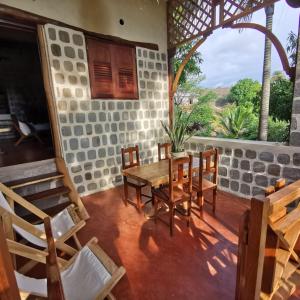 une salle à manger avec une table et des chaises et une fenêtre dans l'établissement G&J House - Bulle tropicale, à Andilana