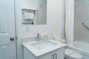 une salle de bain blanche avec un lavabo et des toilettes dans l'établissement Mountain View Hope Motel, à Hope 60 autres photos