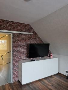 a flat screen tv sitting on top of a white entertainment center at Wunderschöne Ferienwohnung Mit Terrasse Und Garten in Waabs +11 photos