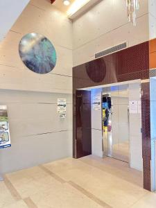 a lobby with two elevators and a clock on the wall at Metacity MK 名廸旺角 in Hong Kong