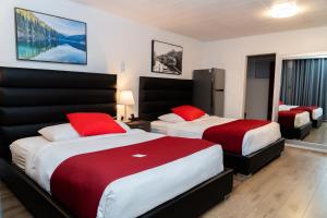 Una habitación de hotel con dos camas con almohadas rojas. en Mountain View Hope Motel, en Hope