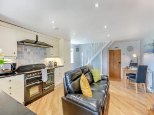 a living room with a leather couch and a kitchen at Beacon - Uk44719 in Ravenscar