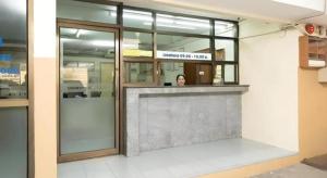 uma mulher atrás de um balcão num edifício em SURANG MANSION em Ban Bang Khen (1)