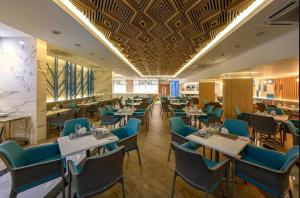 a dining room with tables and blue chairs at C245 Steps from the Beach Pool & Ocean View in Ban Saiyuan (1)