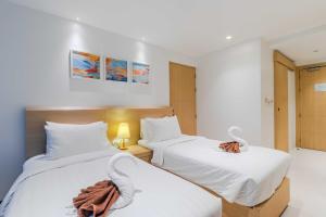 two beds in a room with white sheets at C245 Steps from the Beach Pool & Ocean View in Ban Saiyuan (1)