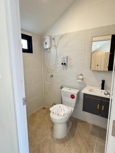 a bathroom with a toilet and a sink at Seashell Family-555普吉岛木屋走几步到邦涛海滩看日落周边餐饮方便 in Bang Tao Beach