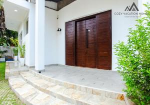 阿努拉德普勒Cozy Vacation Home的白色房子的木门,有楼梯