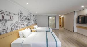a hotel room with two beds and a tv at City Comfort Inn Hengyang Baishazhou in Hengyang