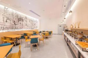 a restaurant with tables and chairs in a cafeteria at City Comfort Inn Hengyang East Station Linghu Wanda Industry College in Xiantang