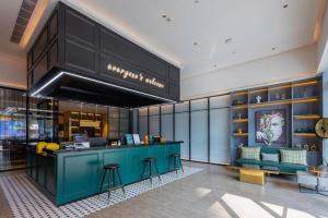 un hall d'un magasin avec un comptoir bleu et des chaises dans l'établissement City Comfort Premier Hotel Nanning Guangxi University Zoo Metro Station, à Nanning