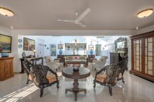 un salon avec des chaises et une table dans l'établissement SaffronStays Brunton House, Alibaug - luxury pool villa near Awas Beach, à Alibaug 20 autres photos