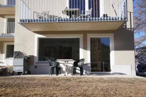 Un patio con una mesa y sillas frente a un edificio. en Chesa Clavadels, en Pontresina
