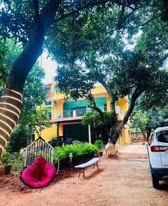 KuilapayamCalm Nest的一座黄色的建筑,在一座建筑前方有树木