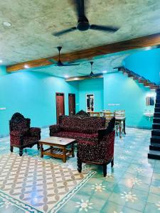 KuilapayamCalm Nest的客厅里有沙发、桌子和蓝色的墙壁。