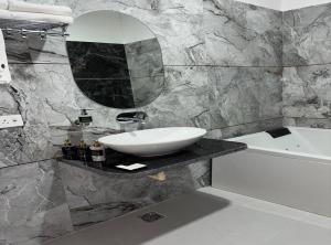 a bathroom with a sink and a mirror and a tub at The Silk Route Resort in Chanderi +95 photos
