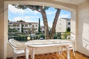 Appartement Tout Confort في ليه ليكيه: طاولة وكراسي بيضاء على شرفة