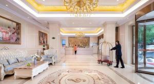 eine Frau mit einem Einkaufswagen in einem Wohnzimmer in der Unterkunft Vienna Hotel Zhejiang Ningbo Beilun In Time City in Ningbo