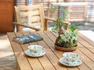 une table en bois avec deux tasses à thé et des plantes en pot dans l'établissement Villa Yoshino - Vacation STAY 01568v, à Azumino 14 autres photos