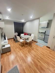 un salon avec une table et des chaises et une cuisine dans l'établissement AC Home 2 Laksi, à Lak Si