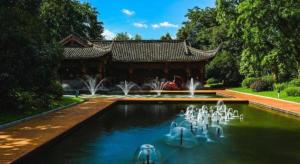 ein Schwimmbad mit Springbrunnen vor einem Gebäude in der Unterkunft Borrman Hotel Chongqing Bishan Central Street in Daxing